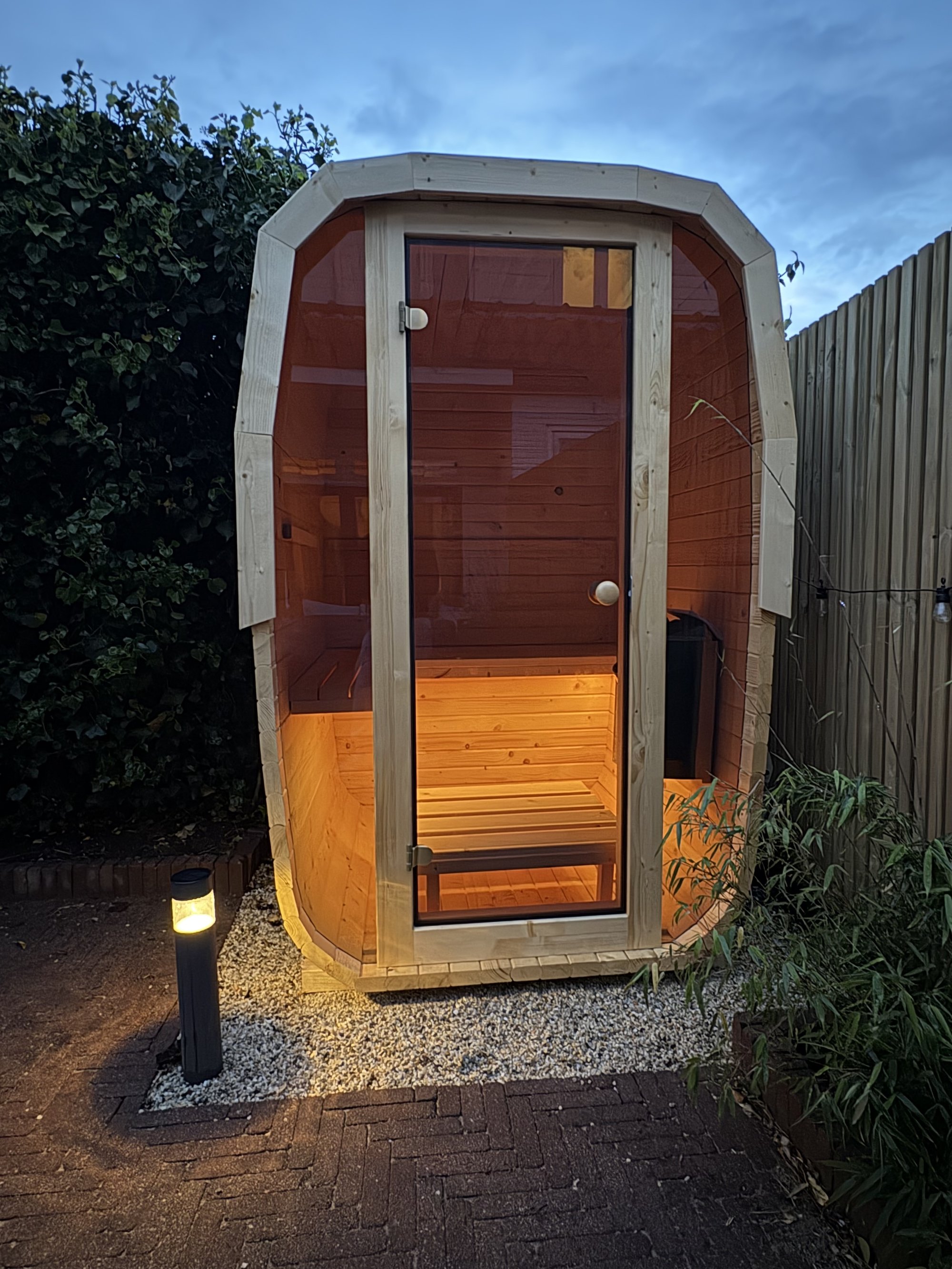 Nordic Cube sauna in de avond, warm verlicht